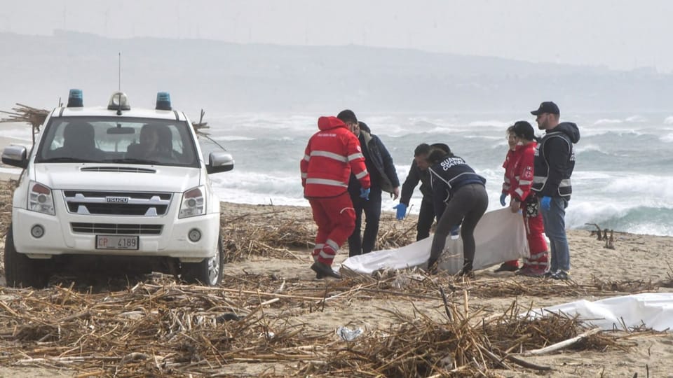 Rescue workers on the beach recover the bodies from the rubble.