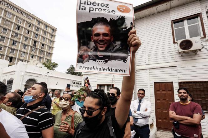 Protesters hold up a photo of Khaled Drareni, a journalist imprisoned during the now free Hirak, in Algiers on September 21, 2020.