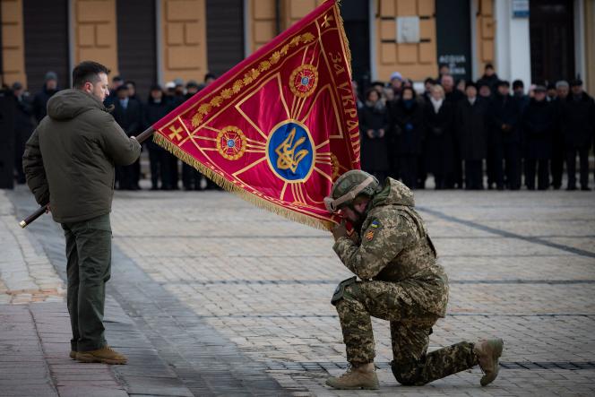 Ukrainian President Volodomyr Zelensky presents a flag to a soldier in Hagia Sophia Square on the first anniversary of the Russian invasion, in kyiv February 24, 2023. 