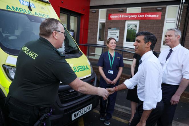 Britain's Prime Minister Rishi Sunak shakes hands with a paramedic next to Health Secretary Steve Barclay during a visit to North Tees University Hospital in Stockton-on-Tees on January 30 2023. 