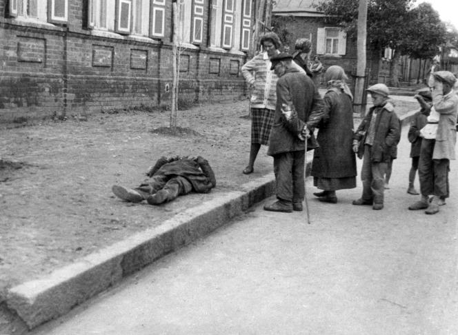 Clandestine photo by Alexander Wienerberger of passers-by watching a starved man on the sidewalk in Kharkiv, Ukraine, 1933.