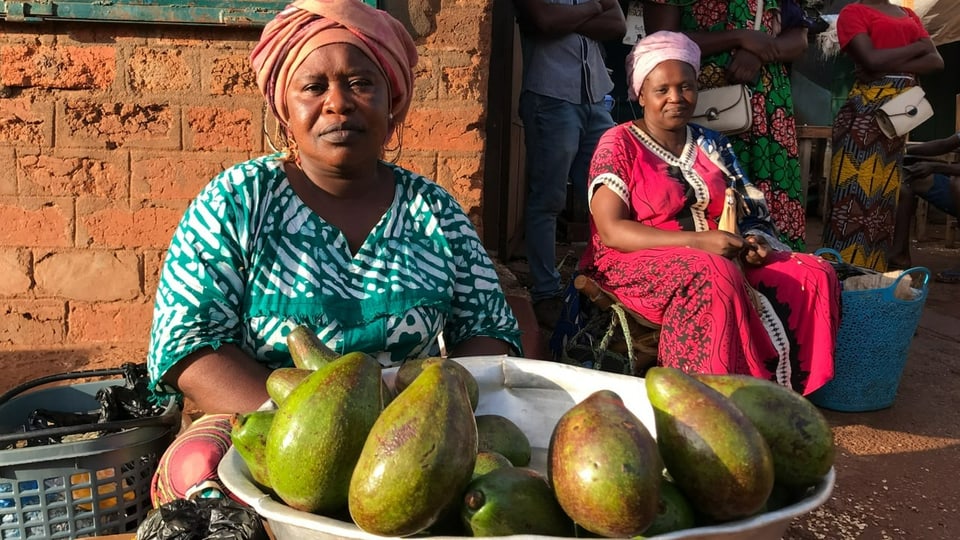Saleswoman sits in front of a bowl of avocados