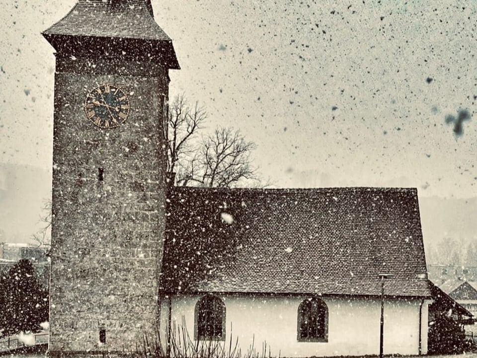 Snow is falling, you can see a church with a steeple