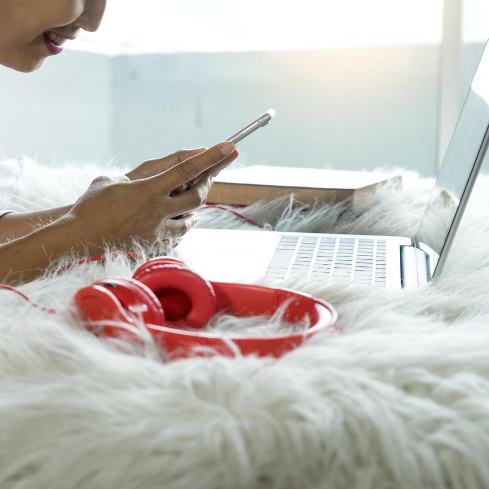 These habits make you stupid: woman with smartphone and laptop in bed