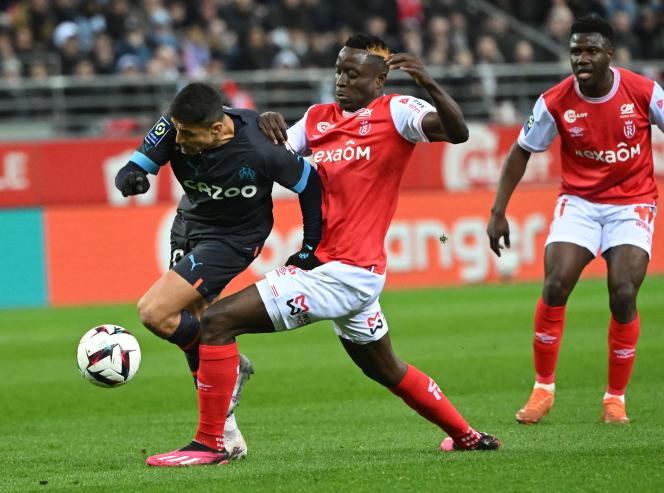 Chilean striker from Marseille, Alexis Sanchez (black jersey) tries to escape Rémois Folarin Balogun, during the 28th day of Ligue 1, March 19, 2023, at the Stade Auguste-Delaune in Reims.