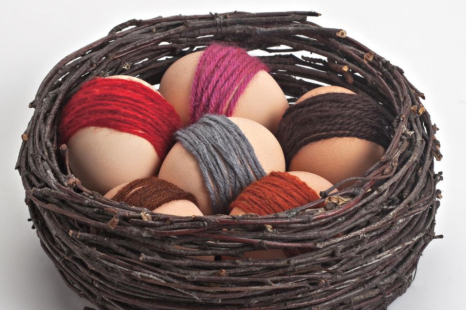 Designing Easter eggs: Easter eggs with a wool border in the nest