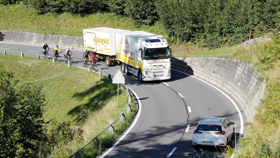 Volvo truck of the Einsiedler Bier brewery overtakes cyclists