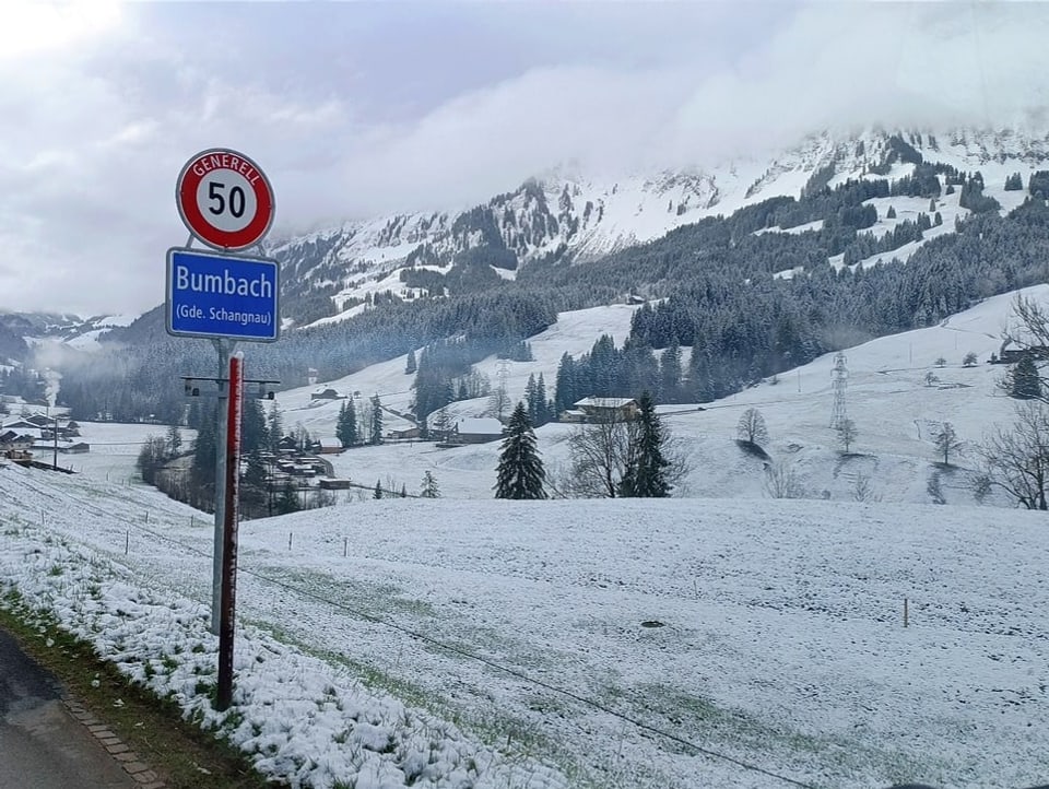 View of snowy landscape with street sign from Bumbach