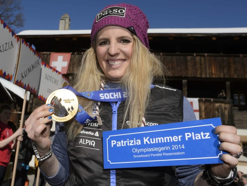 Patrizia Kummer is celebrated, she raises her Olympic medal to the camera
