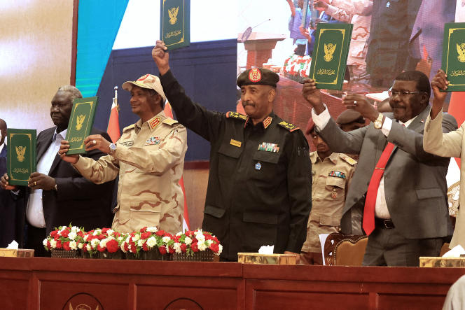 Sudanese army chief Abdel Fattah Al-Bourhane (center right) and paramilitary commander Mohamed Hamdan Dagalo (center left), during the signing of a provisional agreement to end the deep crisis caused by the 2021 military coup, in Khartoum (Sudan), on December 5, 2022. 