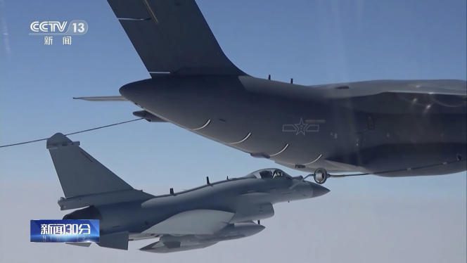 In this image taken from a video broadcast on April 8, 2023 by Chinese television channel CCTV, a Chinese fighter jet performs an in-flight refueling maneuver at an unspecified location.