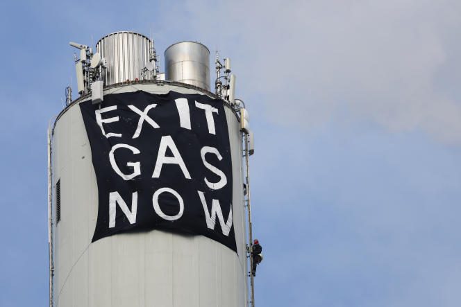 A banner against fossil fuels hangs from the 141-metre-high chimney of the gas-fired power plant in Erlangen, Germany, in March 2023 