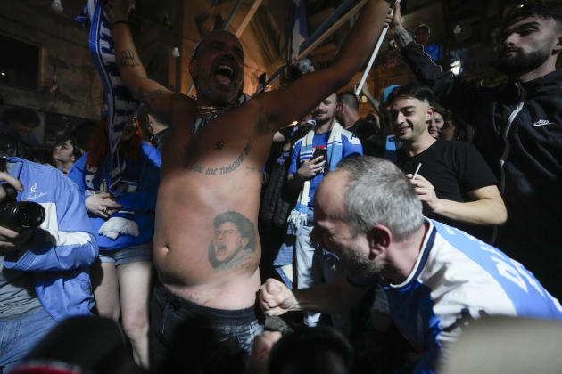 Napoli fans celebrate their team's goal, scored by Victor Osimhen, as they watch a screen broadcasting the match against Udine live, in Naples, Italy, Thursday May 4, 2023.