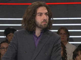 Nicholas Rimoldi.  Long dark hair, beard, blazer, purple top.