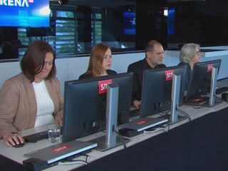 Four fact checkers.  They are all looking at a screen, typing.  One man, three women.