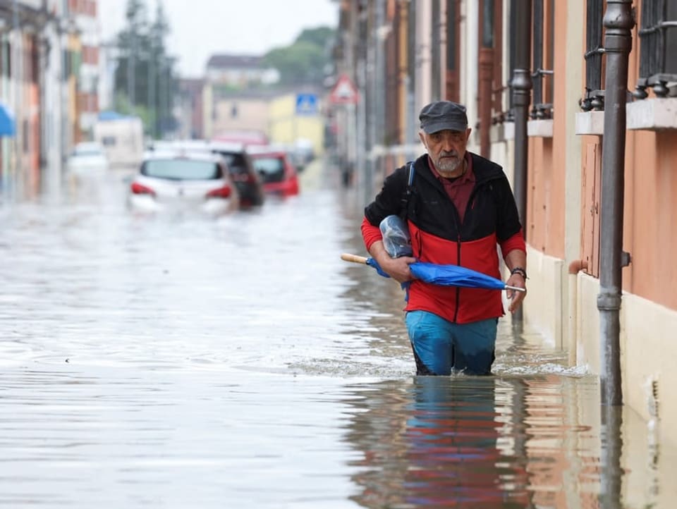 A man wades through floodwaters after heavy rains in the Emilia-Romagna region. 