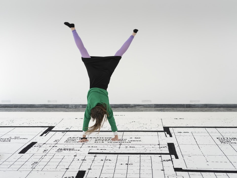 A woman does a cartwheel on an 18x9 meter carpet in the Swiss Pavilion at the Architecture Biennale.