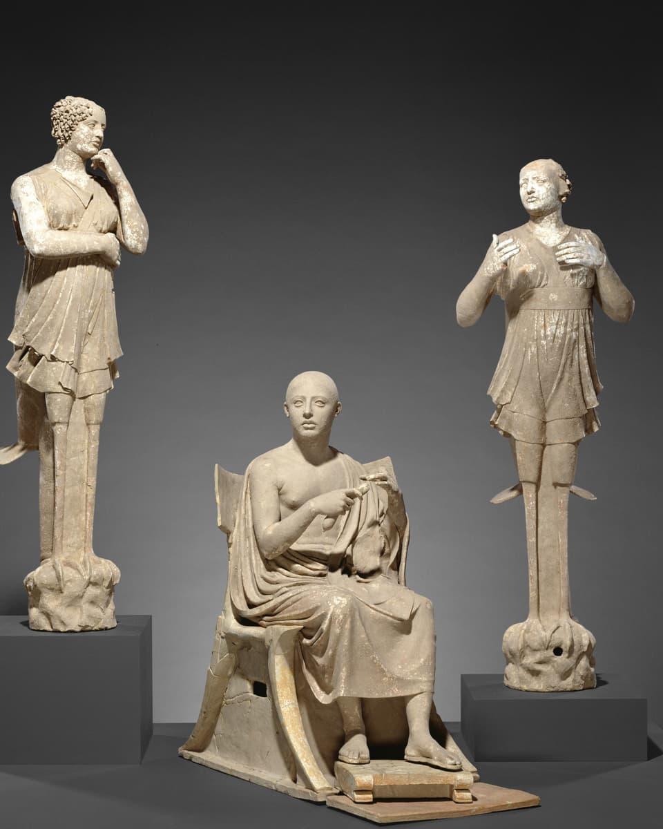 Two ancient statues of women and the ancient statue of a seated poet