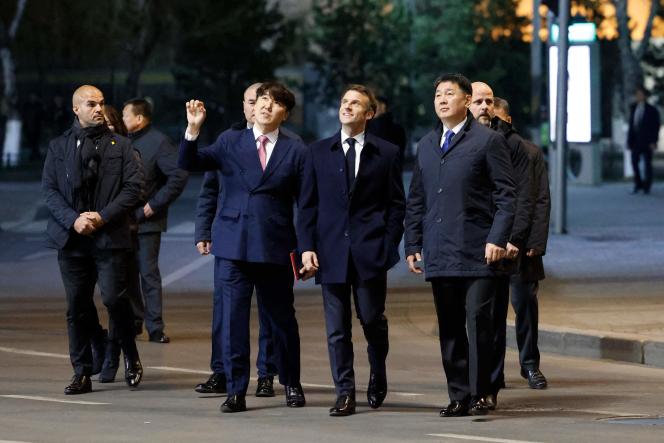 French President Emmanuel Macron (center) with Mongolian President Ukhnaagiin Khürelsükh (right) in the streets of Ulan Bator on May 21, 2023.