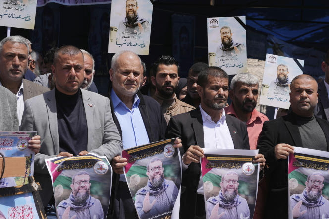 Palestinians hold pictures of Islamic Jihad activist Khader Adnan, who died in an Israeli prison after a hunger strike, outside the office of the International Committee of the Red Cross in Gaza City on May 2, 2023. .