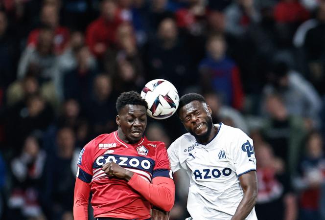 Aerial duel between Lille's Mohamed Bayo (red jersey) and Marseille's Chancel Mbemba, May 20, 2023, in Villeneuve-d'Ascq.