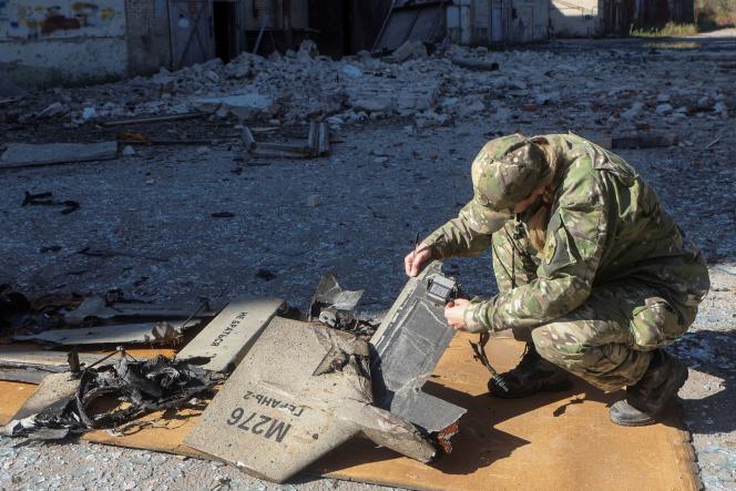 A Ukrainian policeman inspects the wreckage of a Shahed-136 drone, of Iranian origin, in Kharkiv on October 6, 2022. 