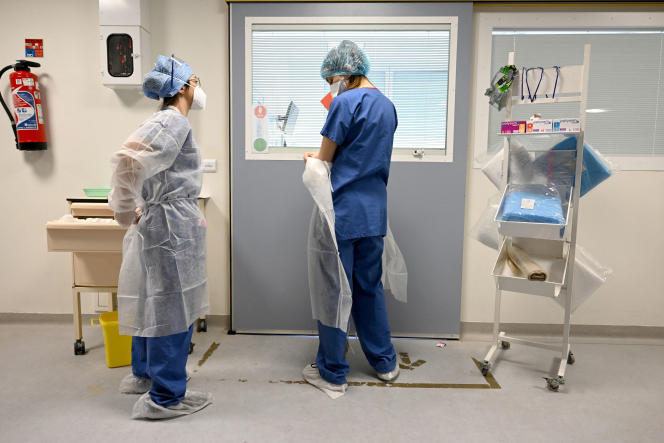 Nurses protect themselves before visiting a patient infected with Covid-19 in the intensive care unit of the Timone hospital, in Marseille, on January 5, 2022. 