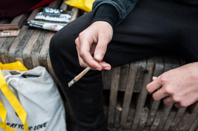 A young man smoking a joint during the Cannaparade, a demonstration in favor of the legalization of cannabis, in Paris, on May 12, 2018.