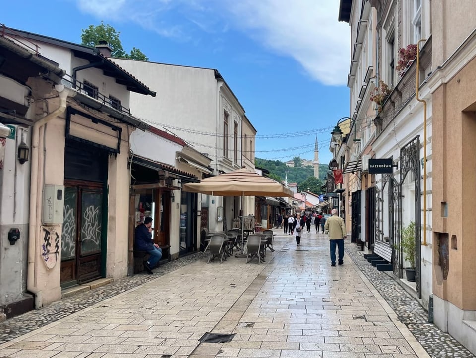 View of an alley in Bascarsija in Sarajevo with shops and people.