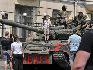Rostow am Don: Ein Kind posiert für ein Foto auf einem Panzer mit der Aufschrift 'Sibirien', während Soldaten der Söldnergruppe Wagner eine Strasse in der Innenstadt von Rostow am Don blockiere (24.6.23)-