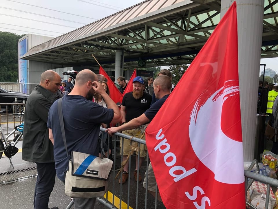 Men at a barrier, red flag