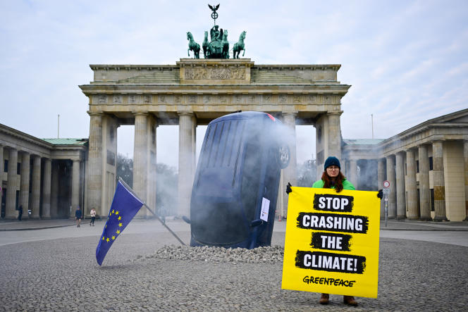 An activist next to an installation set up by Greenpeace in Berlin on March 22, 2023.
