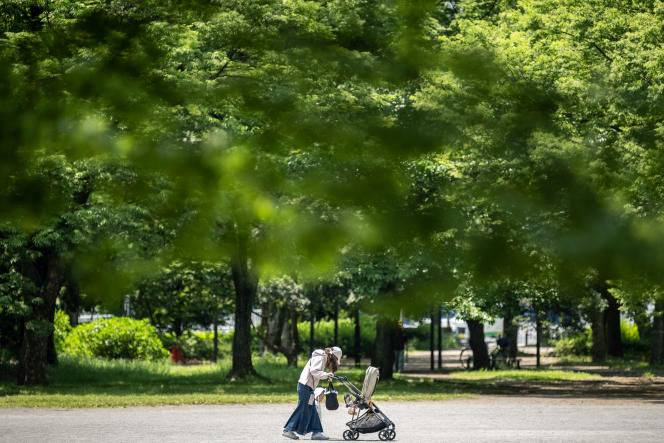 A mother takes her child for a walk in a park in Tokyo, Japan on May 11, 2023. 
