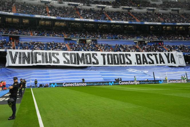 Spectators behind a banner which reads: 'We are all Vinicius' before a Spanish La Liga soccer match between Real Madrid and Rayo Vallecano at the Santiago-Bernabeu stadium, in Madrid, on May 24, 2023. 