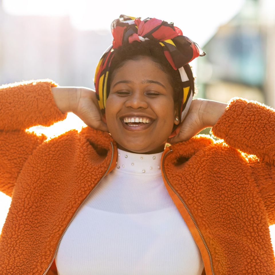 Happy Woman in Orange Jacket: 8 Habits Successful People Cultivate Every Day
