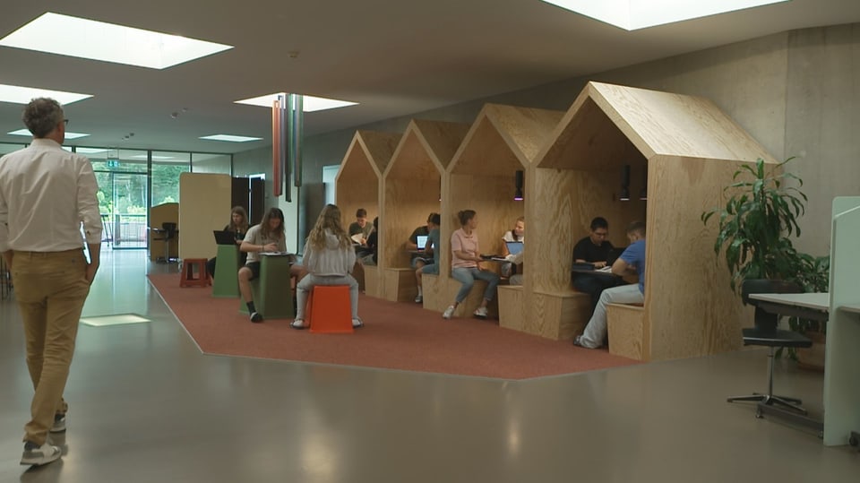 Open wooden houses with tables in a school building