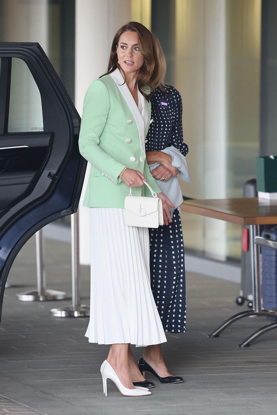 A color combination we've never seen on Catherine, Princess of Wales: For her first visit to the Wimbledon tennis tournament, Kate chooses a light green Balmain blazer with a tailored fit and white exposed buttons.  A contrasting white lapel goes perfectly with the white midi-length pleated skirt.  Now it's getting exciting: because her pumps and her bag from Mulberry are also completely white - daring?  However.  And super stylish! 