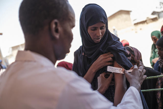 A woman has her arm measured during a food distribution organized by the World Food Program in Adlale, Ethiopia, in April 2022.