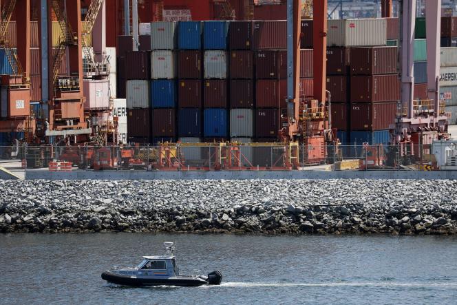 A patrol boat sails past idle containers during a dock workers' strike at Canada's busiest port in Vancouver on July 11, 2023.
