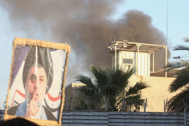 Smoke billowing from the Swedish embassy in Baghdad, and the portrait of Mohamed Al-Sadr (father of Moqtaba Sadr), in Iraq, July 20, 2023.