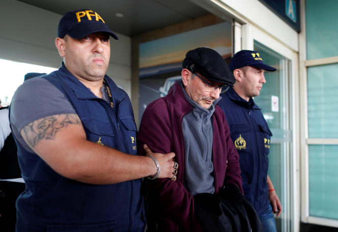 Mario Sandoval, a former Argentine policeman accused of crimes against humanity during Argentina's 'dirty war', is escorted by police officers at Ministro-Pistarini International Airport after being extradited from France, in Buenos Aires, Argentina, on December 16, 2019.
