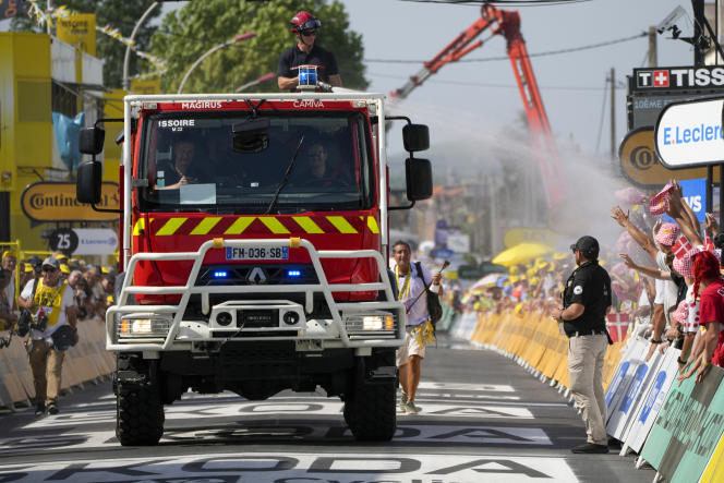 A fire truck sprinkles the public in Issoire (Puy-de-Dôme), July 11, 2023, during the 10th stage of the Tour de France.