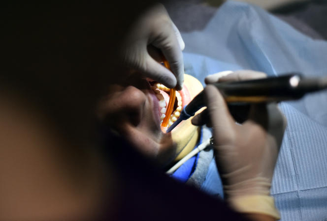   A teenager receives dental treatment on December 4, 2015, in Paris.