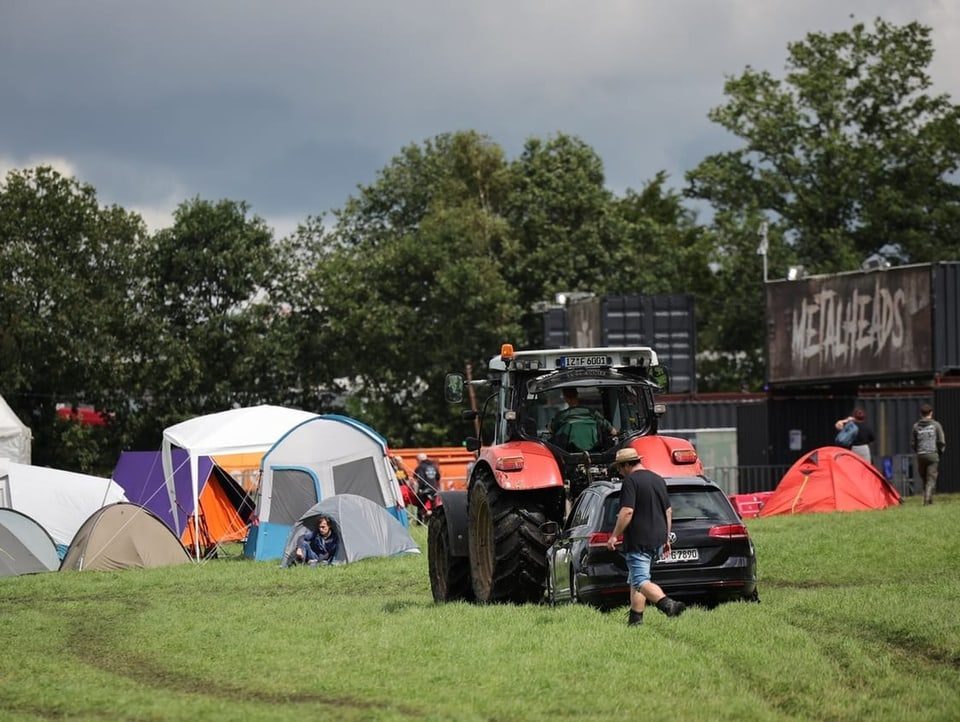 A tractor pulls a visitor's car towards the campsite.