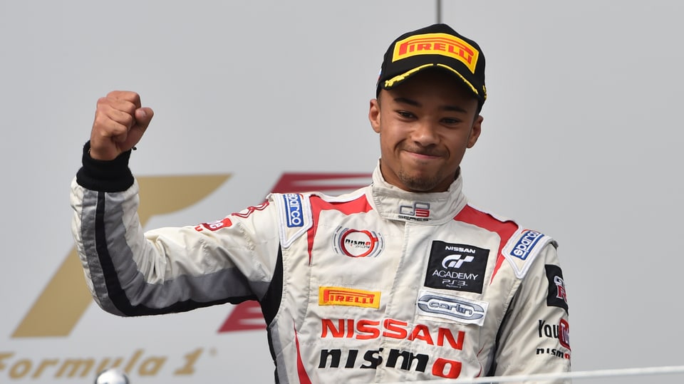 A racing driver shows the victory fist.