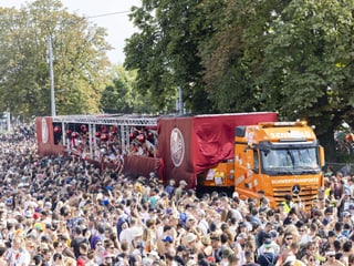 A truck is parked in a large crowd.  The trailer is a dance floor.