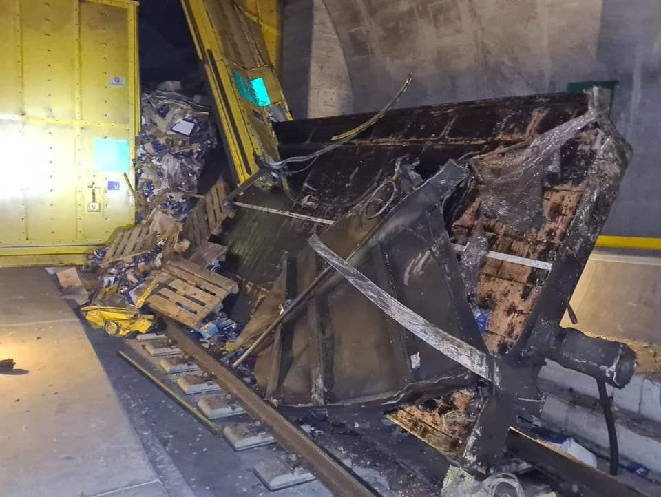 A destroyed railway carriage stands next to the lane change gate in the Gotthard tunnel.