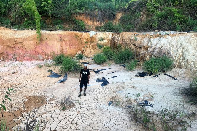 Un villageois montre un bassin abandonné, à l’origine destiné à la première étape du traitement des terres rares d’Ampasindava, dans le nord-ouest de Madagascar, en juin 2023.