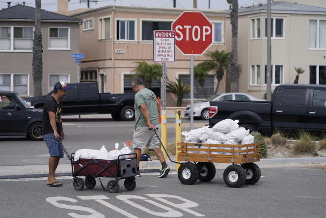 Residents of Long Beach, California, carry sandbags for protection before Hurricane Hilary lands on August 19, 2023.