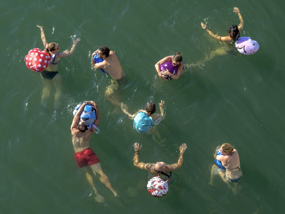 Bird's eye view: people in the water with swimming bags